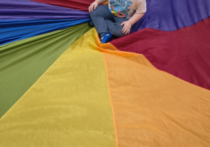 Chłopiec siedzi na środku chusty.