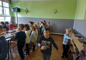 Grupa dzieci ogląda wyposażenie sali komputerowej dla klas I-III.