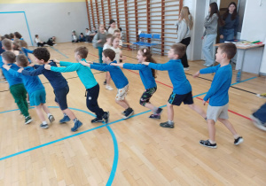 Dzieci idące w "wężu" jedno za drugim.