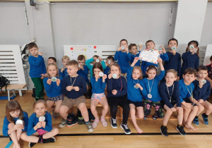 Zdjęcie grupowe dzieci z medalami i dyplomem.