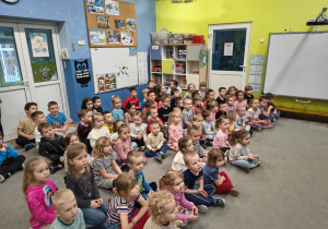 Dzieci siedzą na dywanie