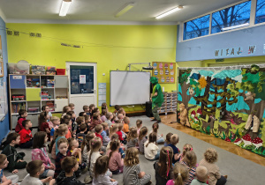 Dzieci siedzą na dywanie