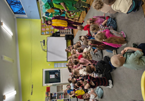 Dzieci siedzą na dywanie