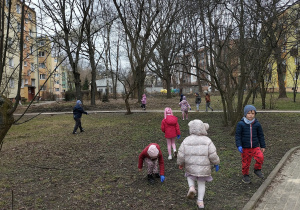 dzieci zbierają smieci koło bloków