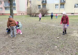 dzieci zbierają śmieci koło bloków