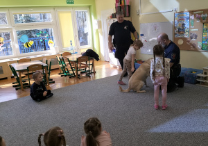 dziewczynki głaszczą psa