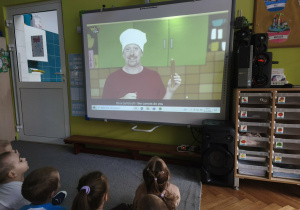 Dzieci oglądają film edukacyjny o warzywach.