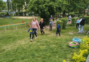 Pracownicy przedszkola maszerujący razem z dziećmi po wyznaczonym torze.