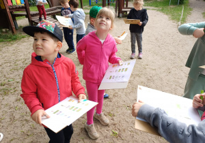 Dzieci szukające obiektów w ogrodzie przedszkolnym.