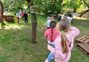 Dzieci szukające wskazanych obiektów przy kręgu z palet.