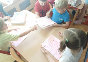 Oddzielanie przez dzieci kartek od sit.
