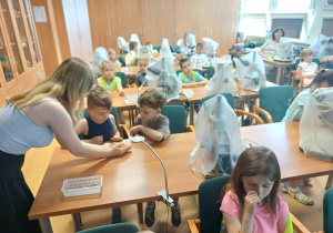Zdjęcie całej grupy siedzącej przy ławkach studenckich.