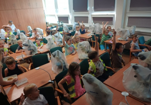 Na zdjęciu dzieci siedzące w sali uniwersyteckiej.