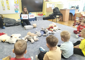 pani prowadząca pokazuje numery alarmowe
