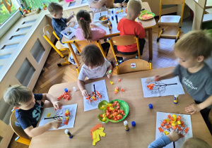 dzieci wykonują jesienne drzewo z kawałków kolorowego papieru