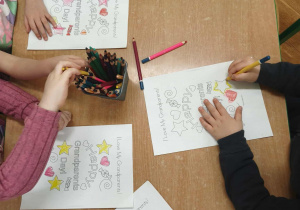 dzieci kolorują obrazek