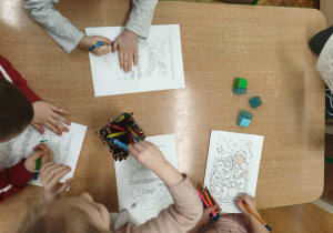 dzieci kolorują obrazek