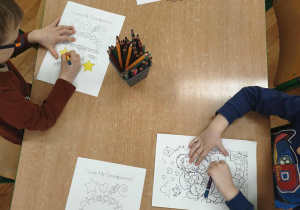 dzieci kolorują obrazek