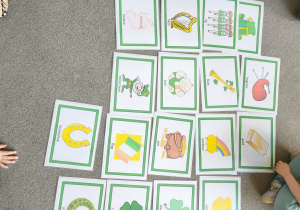 dzieci siedzą przy stoliku i kolorują ilustracje